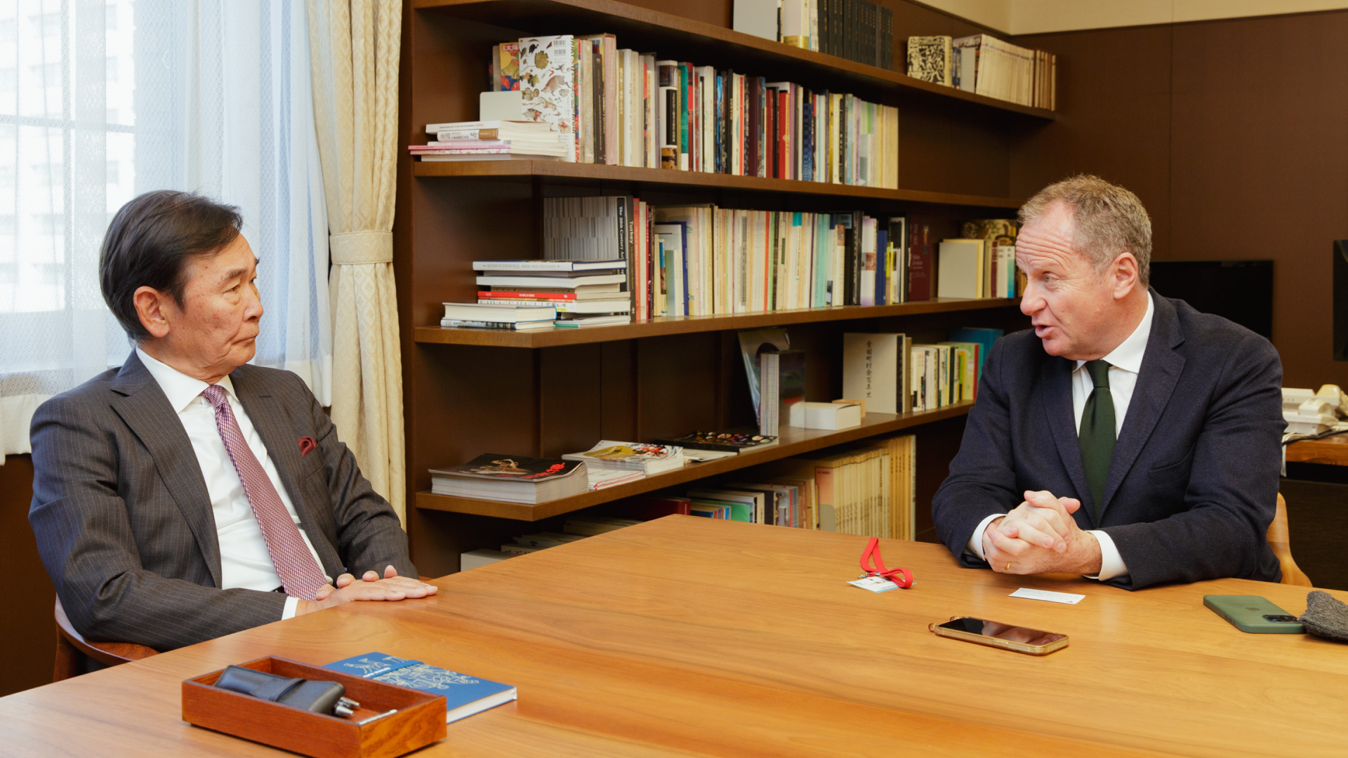 Saffron CEO Jacob Benbunan and Japan Minister of Culture Shunichi Tokura sit at a table in coversation
