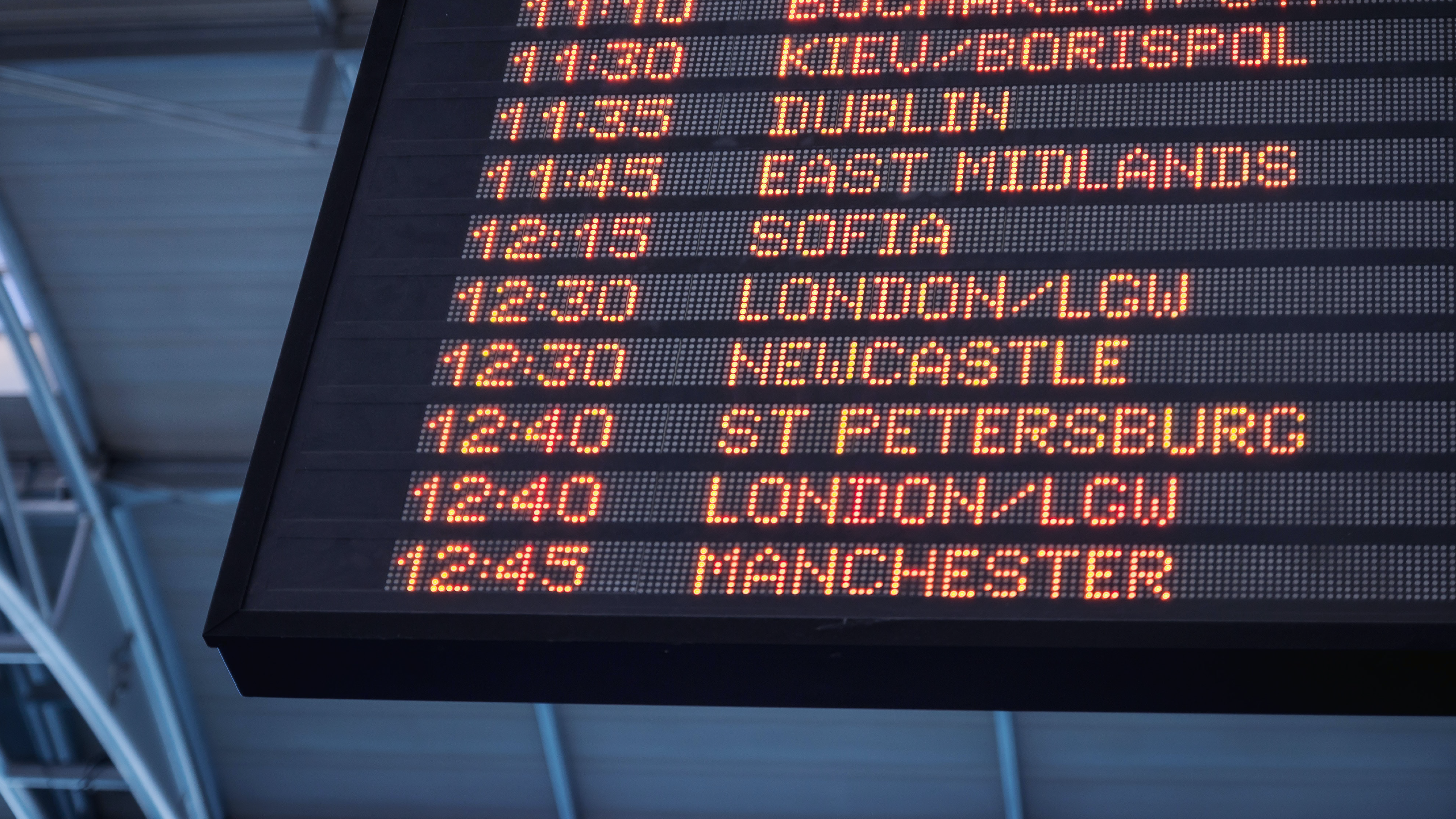 Airport departure board displaying flight times and destinations